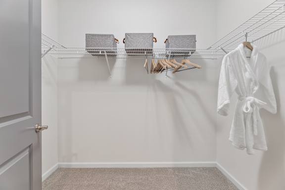 A white bathroom with a towel hanging on the wall.