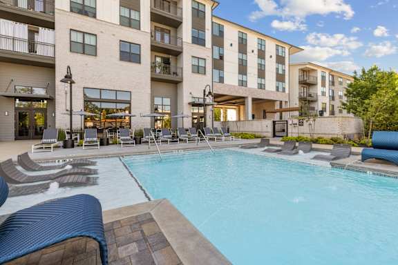 A large swimming pool in front of apartment buildings.