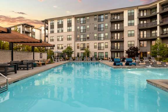 A large swimming pool in front of apartment buildings.