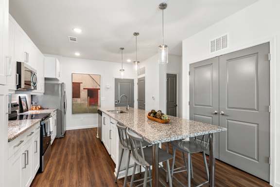 A kitchen with a table and chairs in the middle of the room.