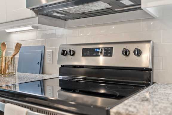 A modern stainless steel oven with digital controls is installed in a kitchen.
