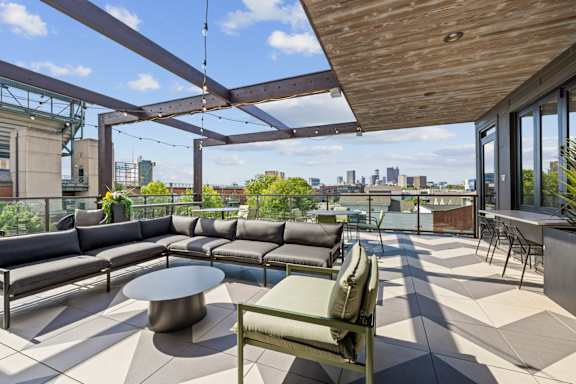 A patio with a table and chairs overlooking a city skyline.