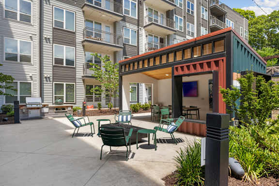 A patio with a table and chairs is surrounded by apartment buildings.