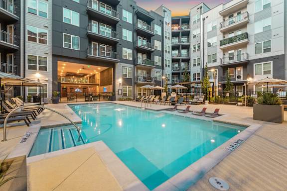 A large swimming pool in front of apartment buildings.