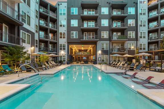 A large indoor swimming pool in front of apartment buildings.