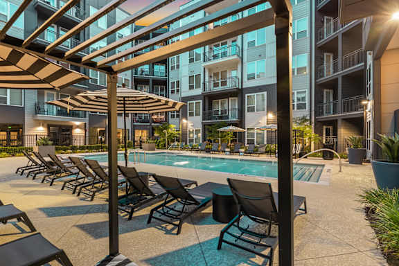 A pool area with sun loungers and a canopy.