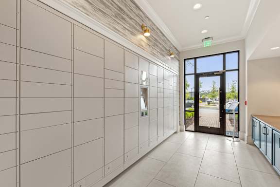 A hallway with a tile floor and a wall of lockers.