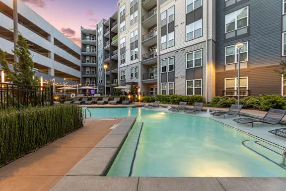 A swimming pool in a residential area surrounded by buildings.