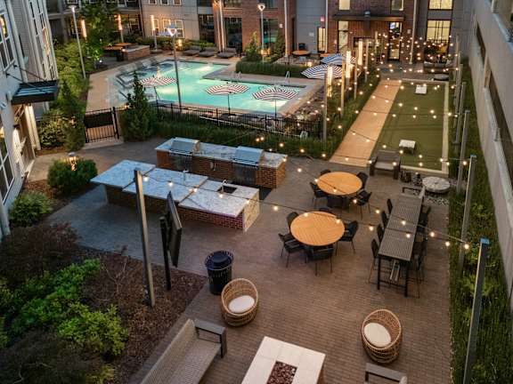 A rooftop patio with a pool and furniture.