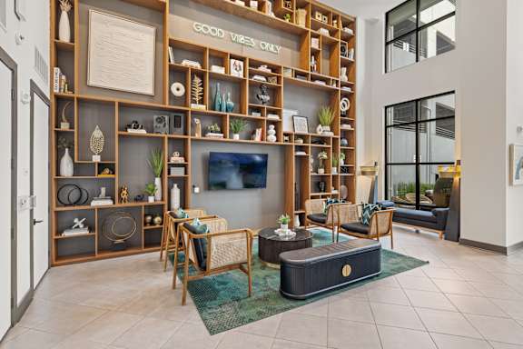 A living room with a flat screen TV and a large wooden shelf with various items on it.