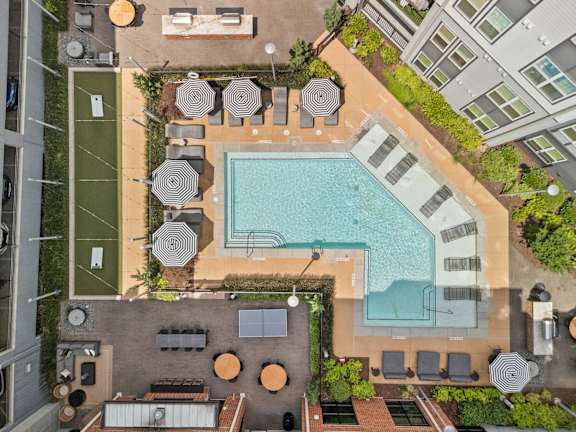 An aerial view of a pool surrounded by lounge chairs and umbrellas.