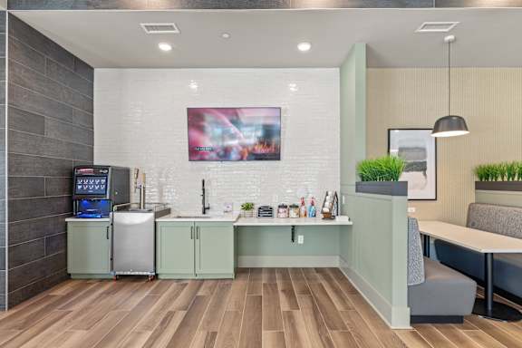 A modern kitchen with a wooden floor and a fridge on the left.