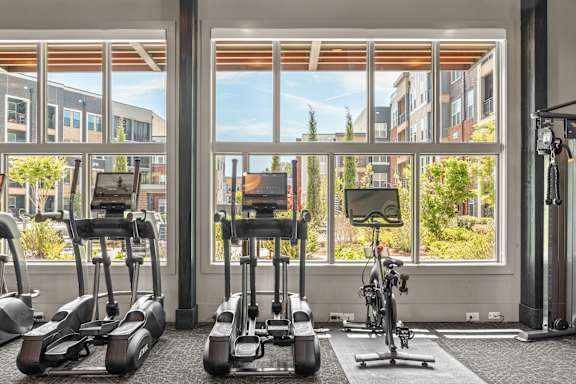 A gym with treadmills, exercise bikes, and a weight machine.