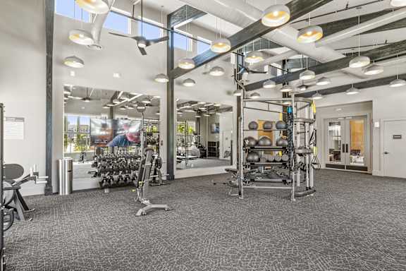 A gym with a variety of equipment including weights and cardio machines.