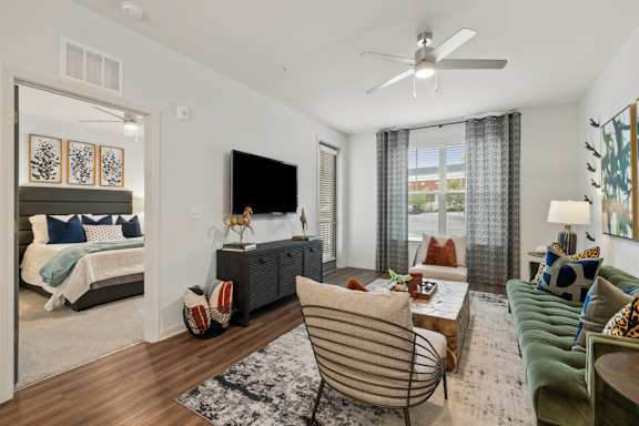 A living room with a green couch and a television.