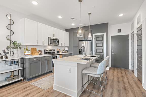 A modern kitchen with a large island and a dining area.