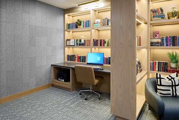 A room with a desk, chair, and bookshelf.