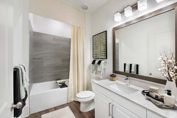 A bathroom with a white tub, toilet, and sink.