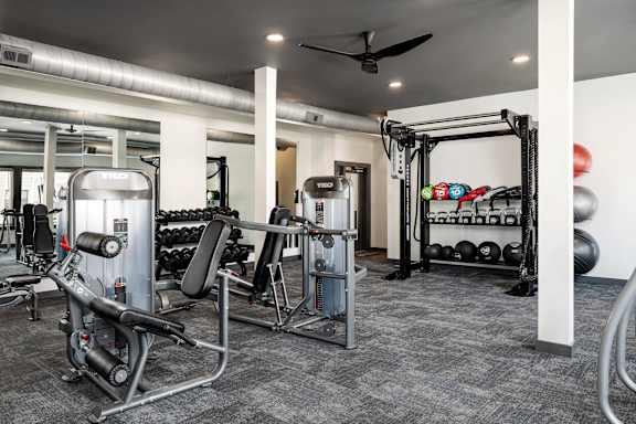A gym with a variety of equipment including a leg press machine.