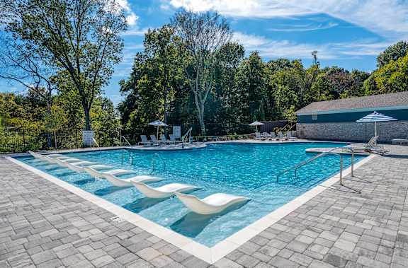 A large outdoor swimming pool surrounded by trees.
