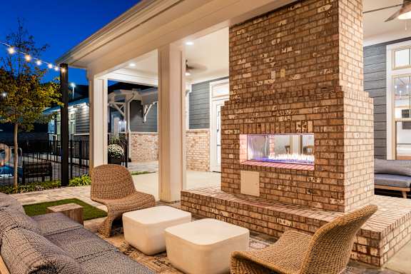 A patio with a fireplace and seating area.