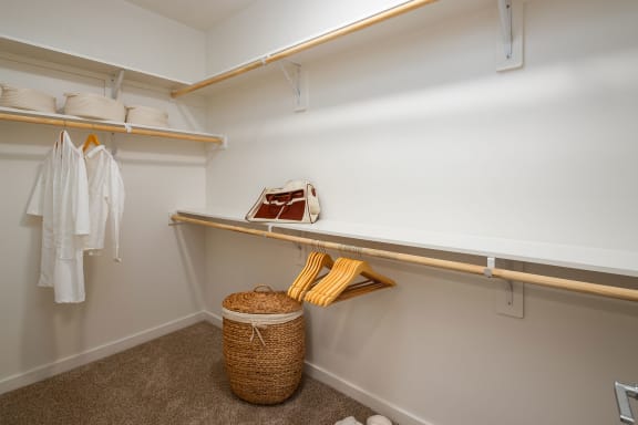a walk in closet with shelves and a basket