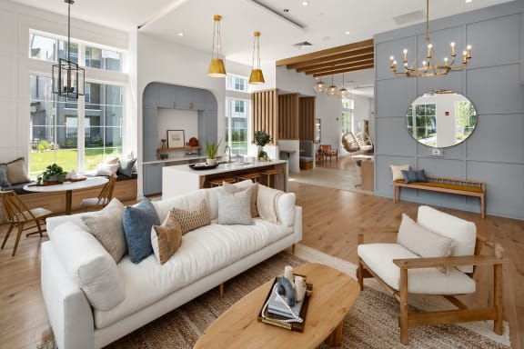 a large living room with a white couch and a kitchen