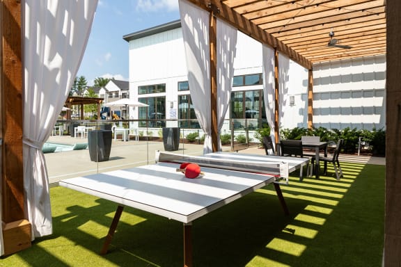 a group of ping pong tables on a patio with a building in the background