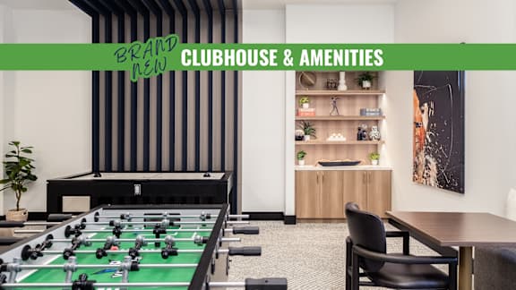 A foosball table is in the middle of a room with a green table top.
