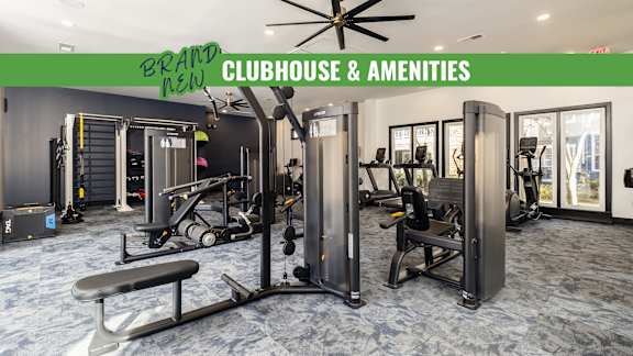 A gym with a green sign that says "Brand New Clubhouse & Amenities".