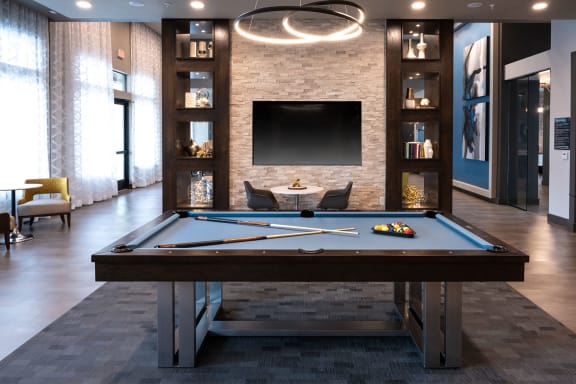 a games room with a pool table and a television
