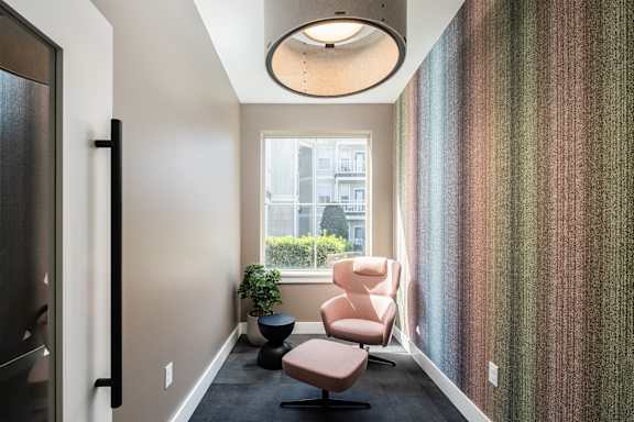 A hallway with a chair and a plant.