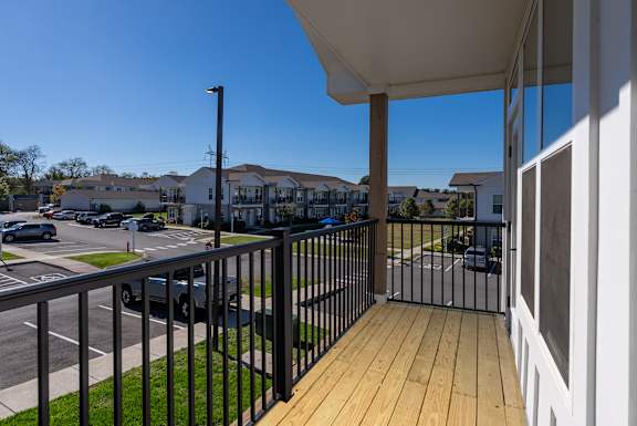 A balcony with a black railing and a white wall.