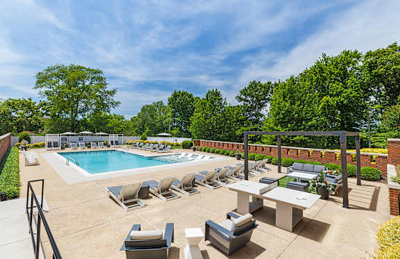 A large outdoor pool area with lounge chairs and umbrellas.