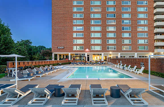 A large building with a pool in front of it.