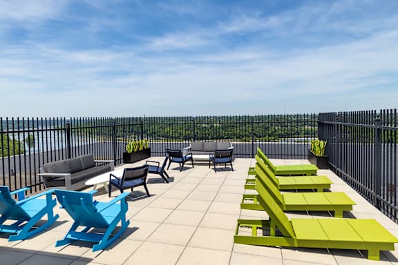 A patio with blue and green chairs and tables.