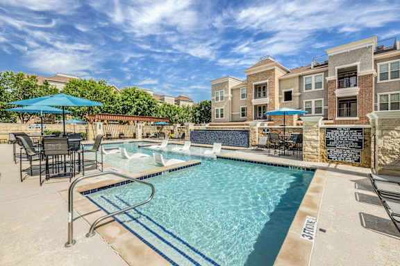 A swimming pool with a slide and a wall with a plaque on it.