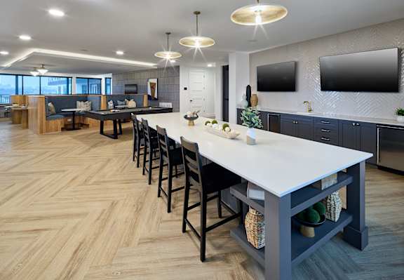 A modern kitchen with a long table and chairs.