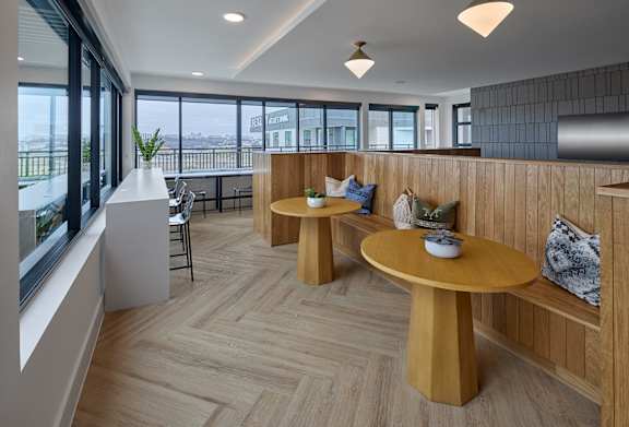 A modern dining area with wooden furniture and a view of the city.