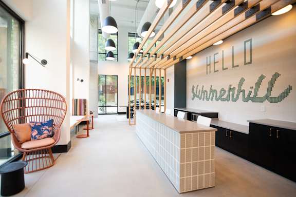 A reception area with a white reception desk and a wall with the word "Hello" written on it.