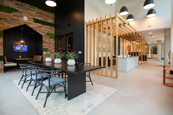A modern dining area with a long table and chairs.
