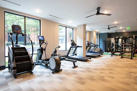 A gym with treadmills, elliptical machines, and other exercise equipment.
