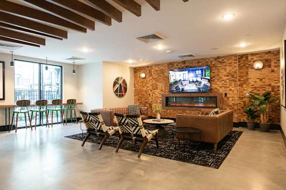A modern living room with a brick wall and a television.