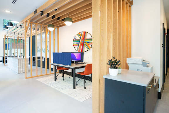 A room with a blue desk and a wooden ceiling.