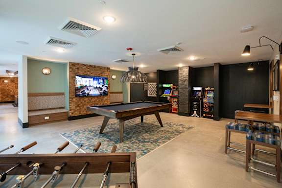 A room with a pool table and a TV.
