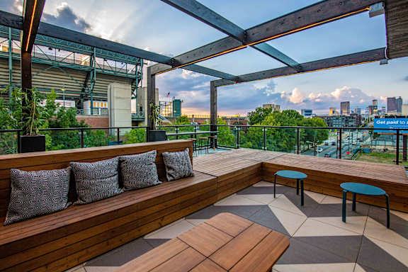 A wooden deck with a bench and two tables.