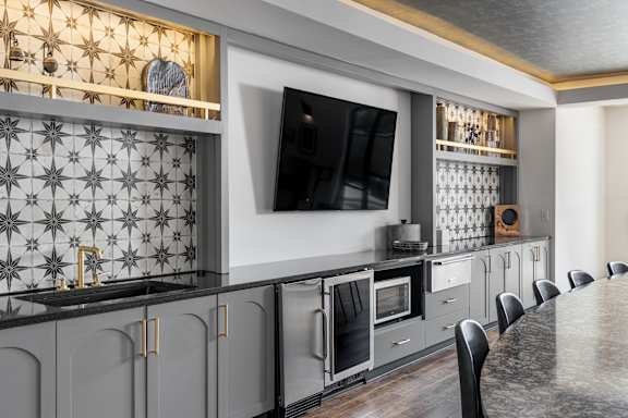 A modern kitchen with a grey and gold color scheme.