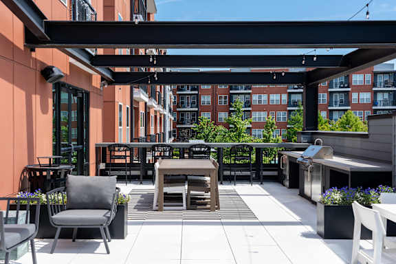 A patio with a table and chairs is surrounded by buildings.