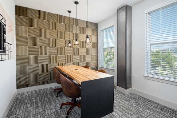A room with a brown wooden desk and a black cabinet.
