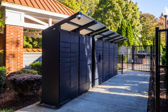a black fence with a gate and a sidewalk in front of a building